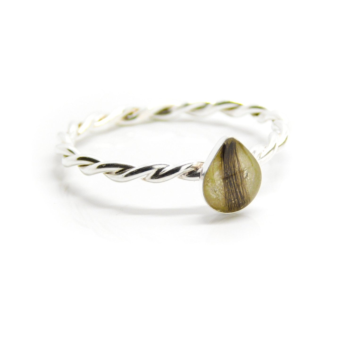 This image shows a sterling silver twisted band ring featuring a small, teardrop-shaped clear stone containing what appears to be a lock of light brown hair. A unique and personal hair keepsake ring.