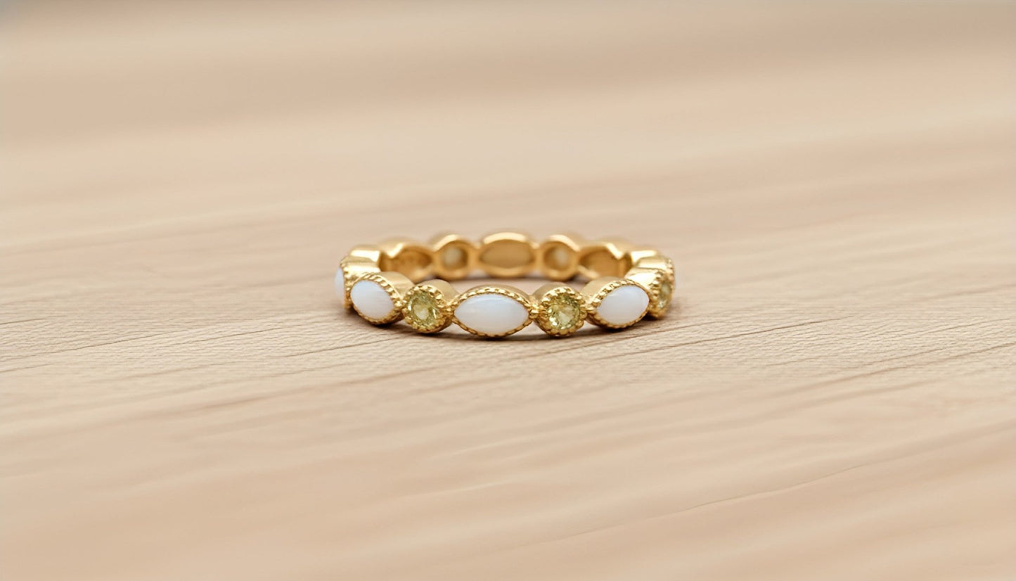 Gold ring with white and yellow stones on a wooden surface